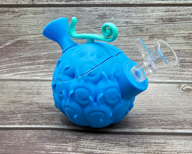 Blue devil fruit water pipe with silicone mouthpiece and clear glass bowl on wood background